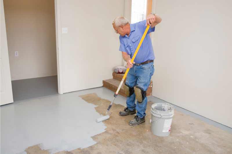 person painting a garage floor